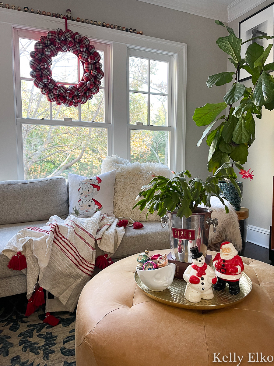 Cozy Christmas family room - love the big plaid wreath, Santa mug pillow and cute vintage snowman kellyelko.com