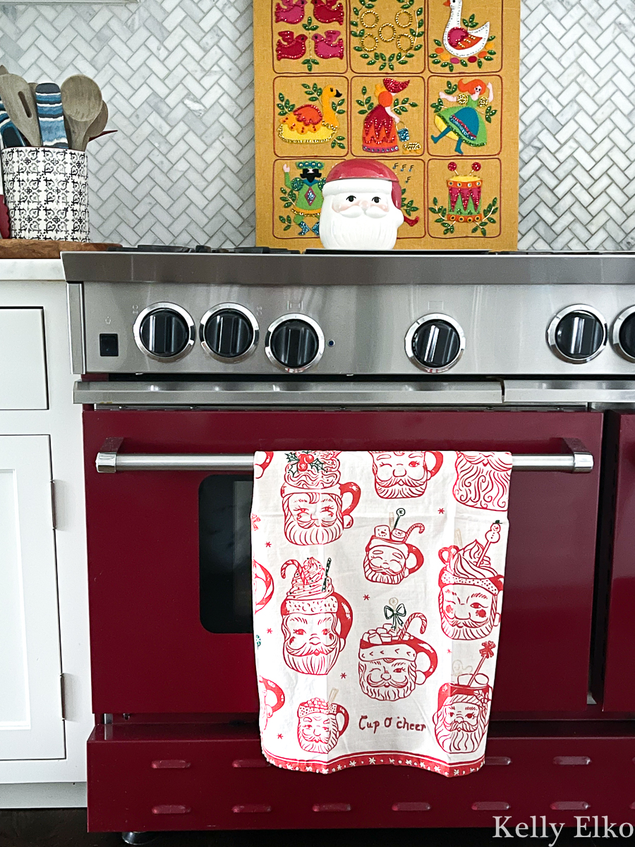 Love this Santa mug dishtowel and red stove in this festive Christmas kitchen kellyelko.com