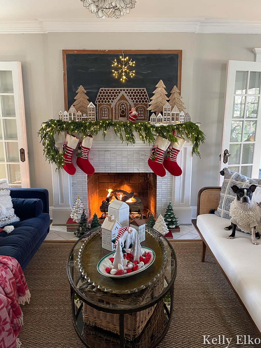Stunning gingerbread house Christmas mantel - I love the antique chalkboard, light up snowflake and handmade wood houses kellyelko.com