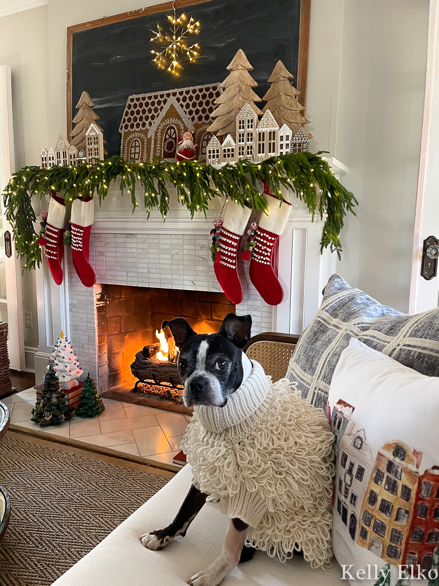 Gingerbread village Christmas mantel - love the realistic garland, fairy lights and giant snowflake plus the cute Boston Terrier in an adorable sweater kellyelko.com