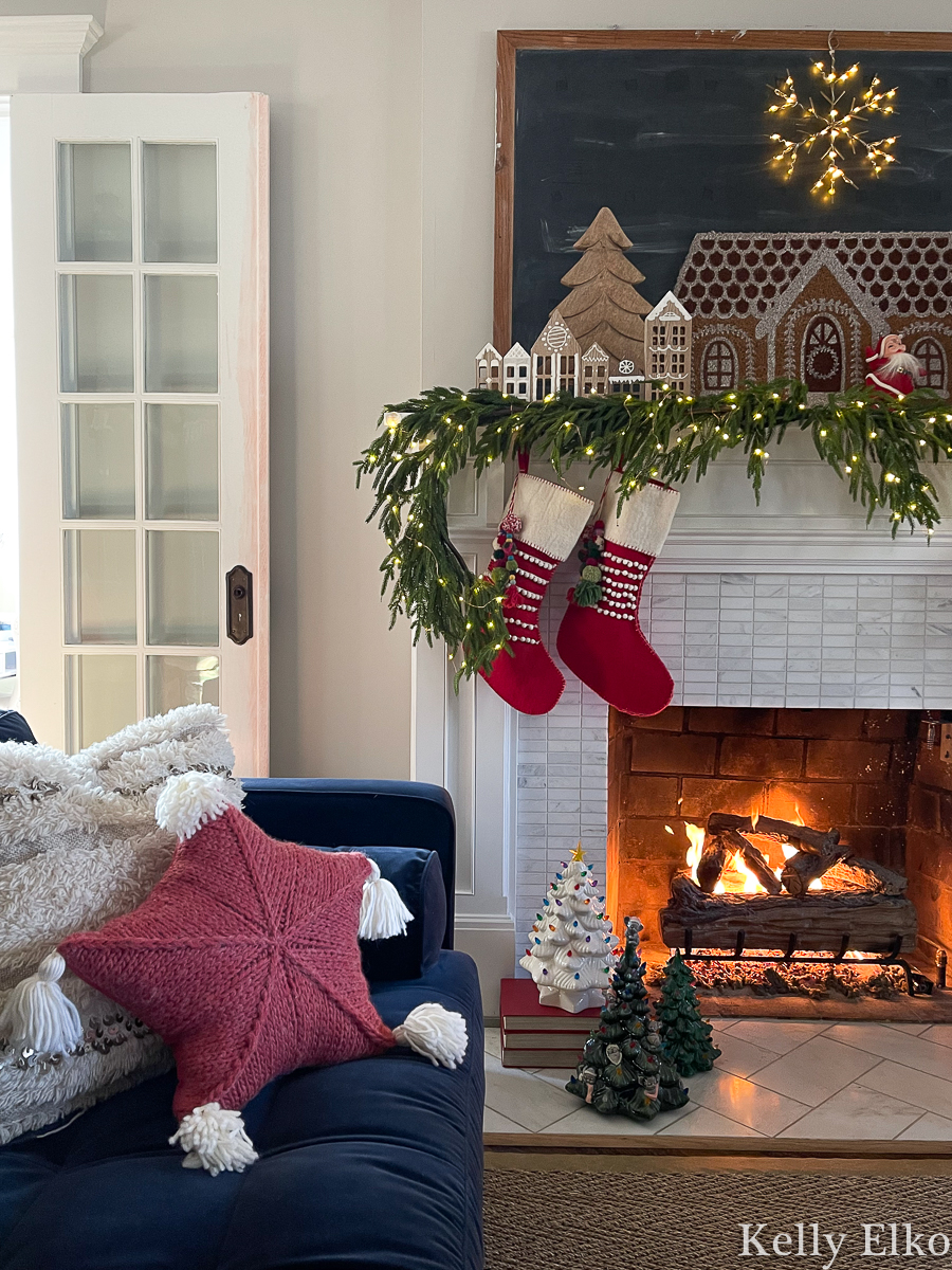 Love this whimsical wood gingerbread house mantel and the cute tassel star pillow and pom pom stockings kellyelko.com