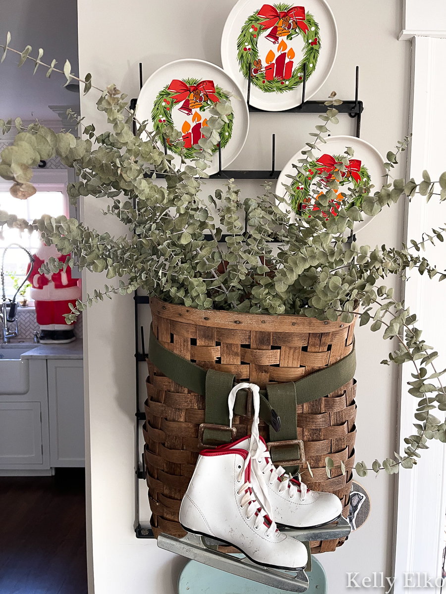 Vintage basket overflowing the eucalyptus and tied with a cute pair of ice skates kellyelko.com