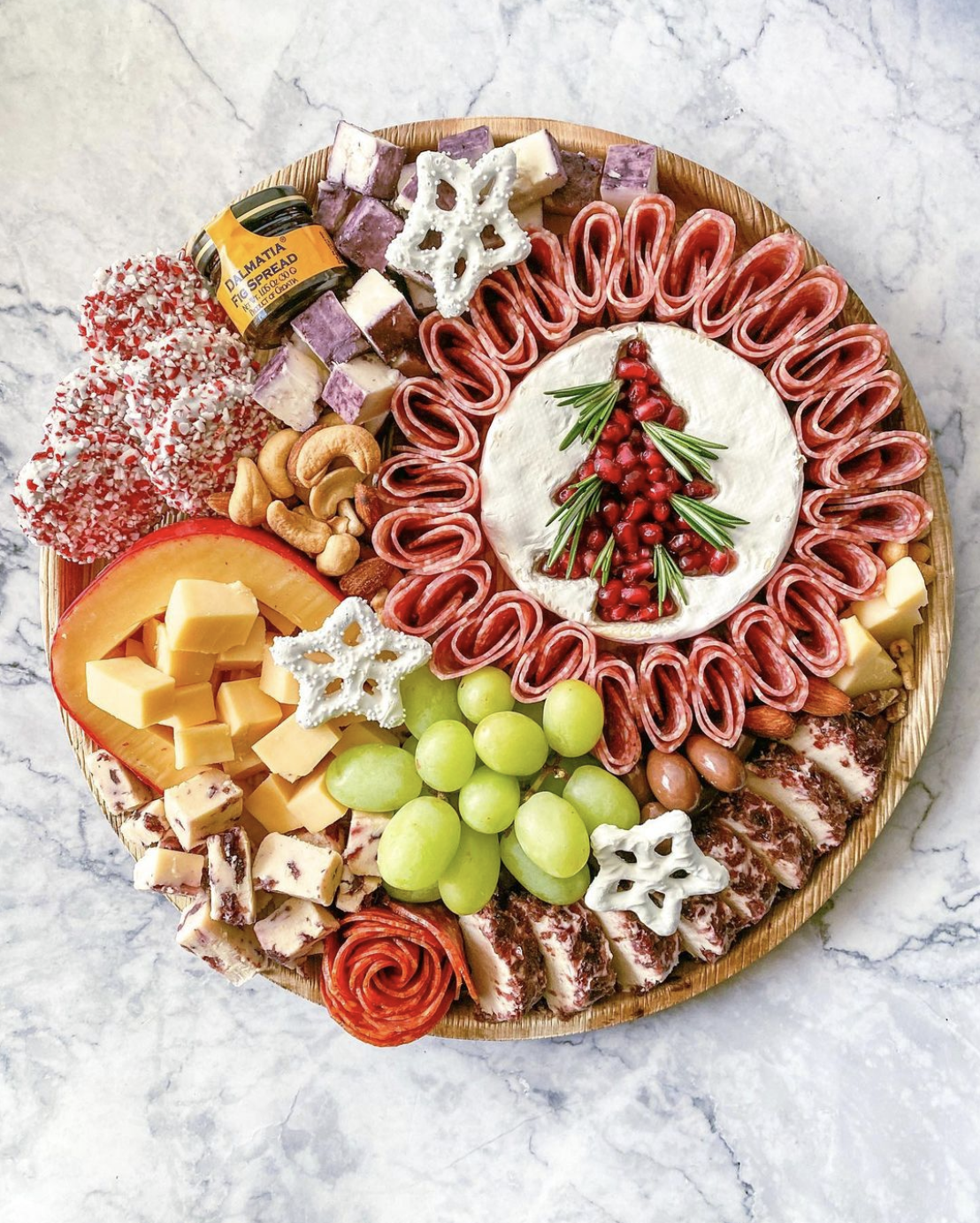 Love this Christmas charcuterie board with tree cutout of brie cheese 