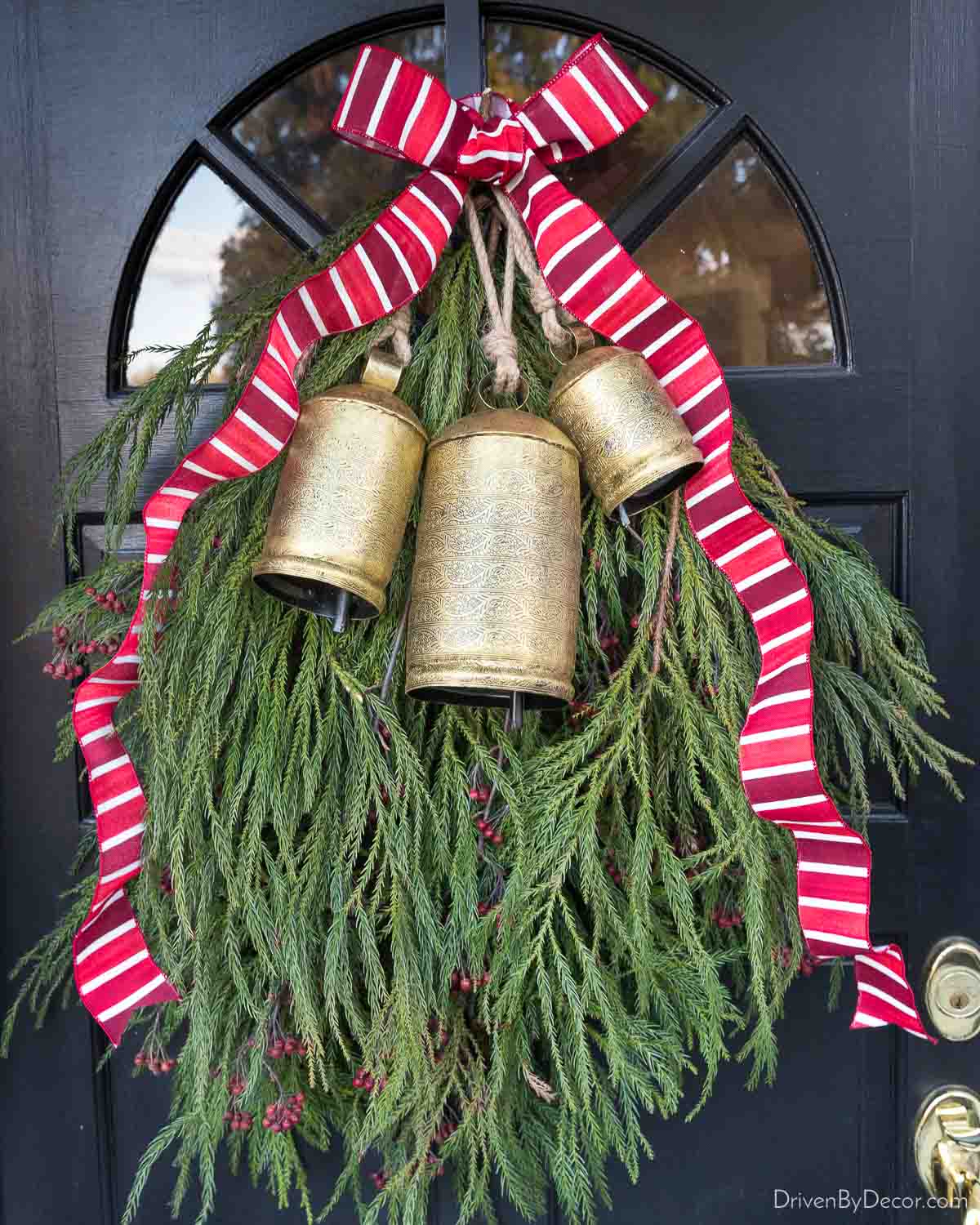 Gorgeous greenery swag with brass bells and red ribbon