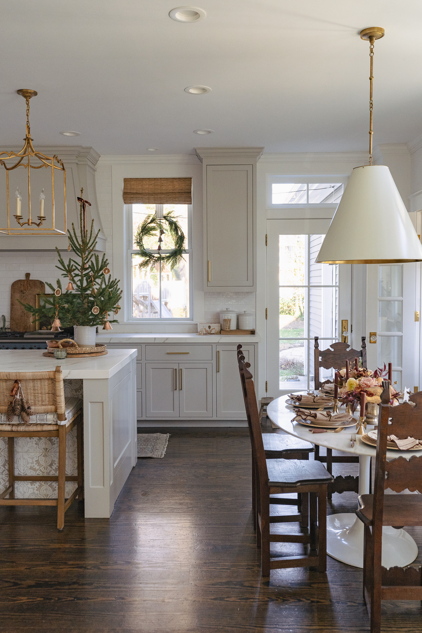 Stunning white kitchen with antique wood chairs and tabletop Christmas tree 