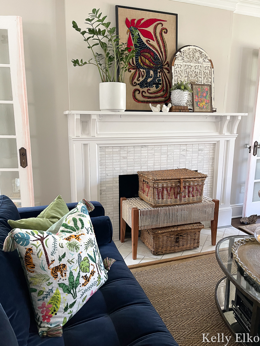 Eclectic mantel with vintage crewel art, baskets, plants kellyelko.com