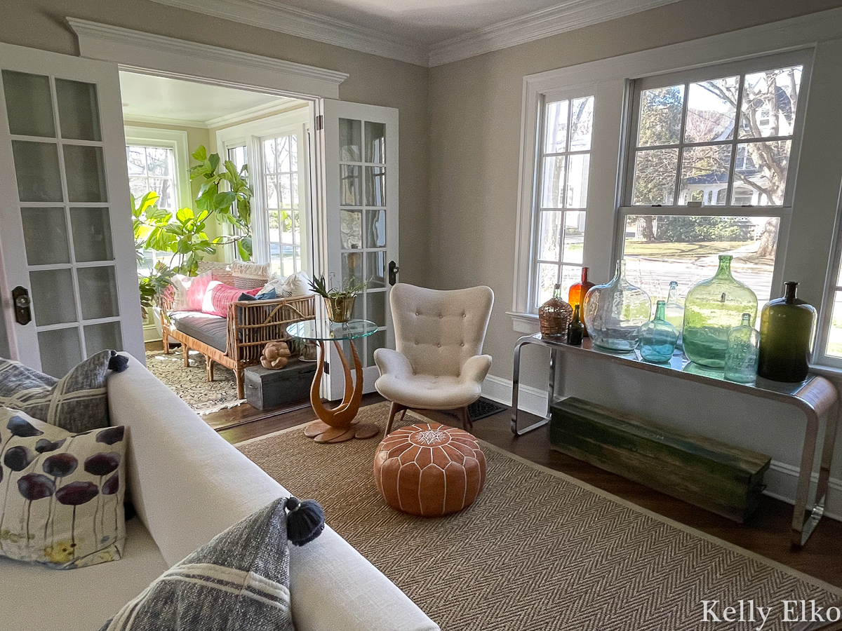 Stunning living room with console table filled with antique demijohn bottles kellyelko.com