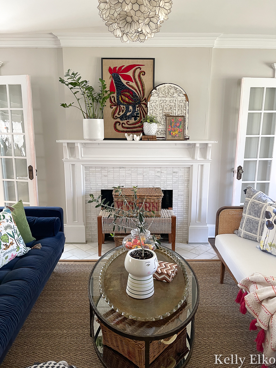 6 Ways to Decorate a Spring Mantel - love this vintage artwork, plants, baskets in this lovely living room kellyelko.com