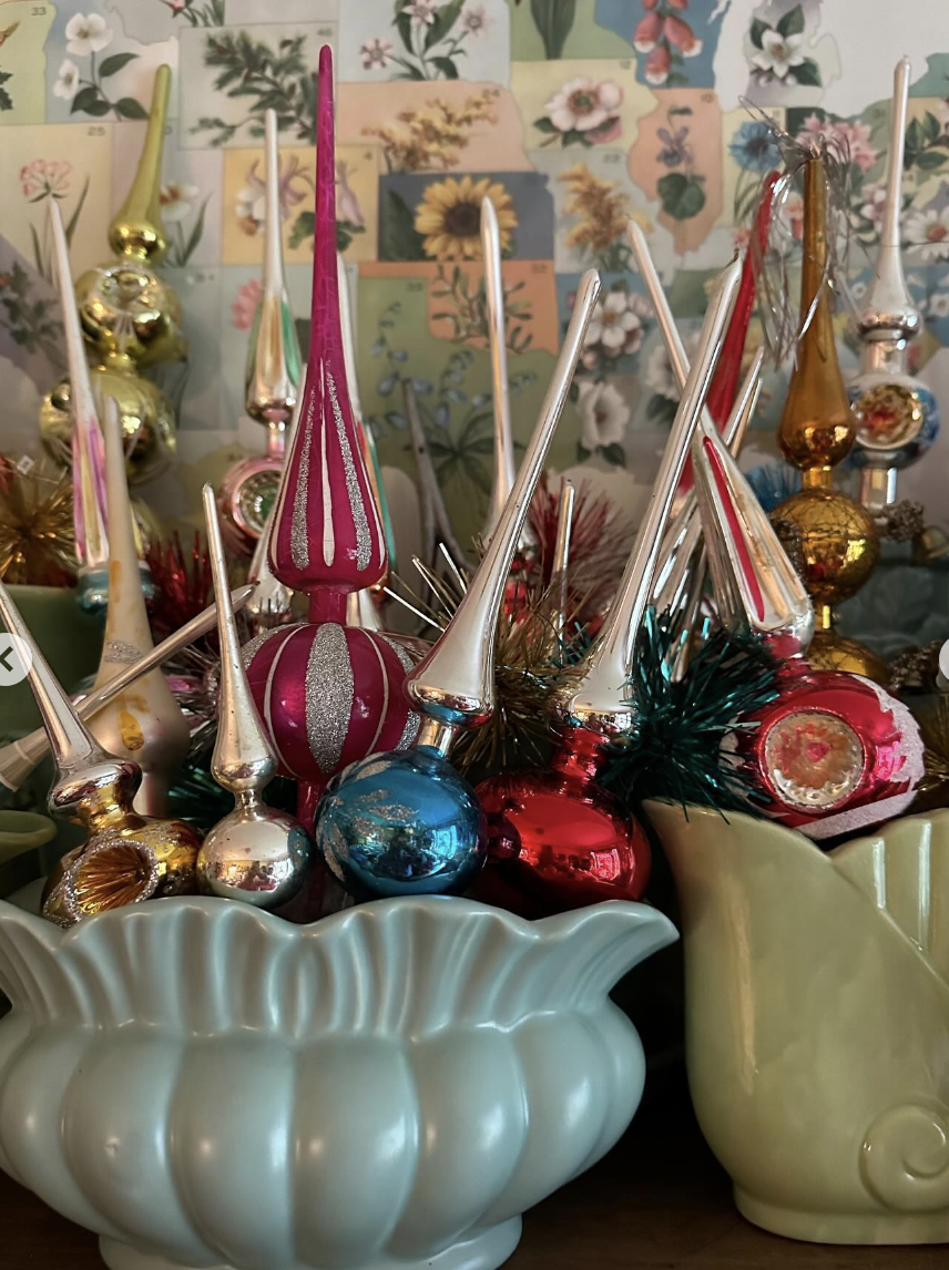 Collection of colorful vintage Christmas tree toppers displayed in vintage pottery / kellyelko.com