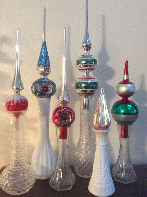 Christmas tree toppers displayed in crystal and milk glass vases / kellyelko.com
