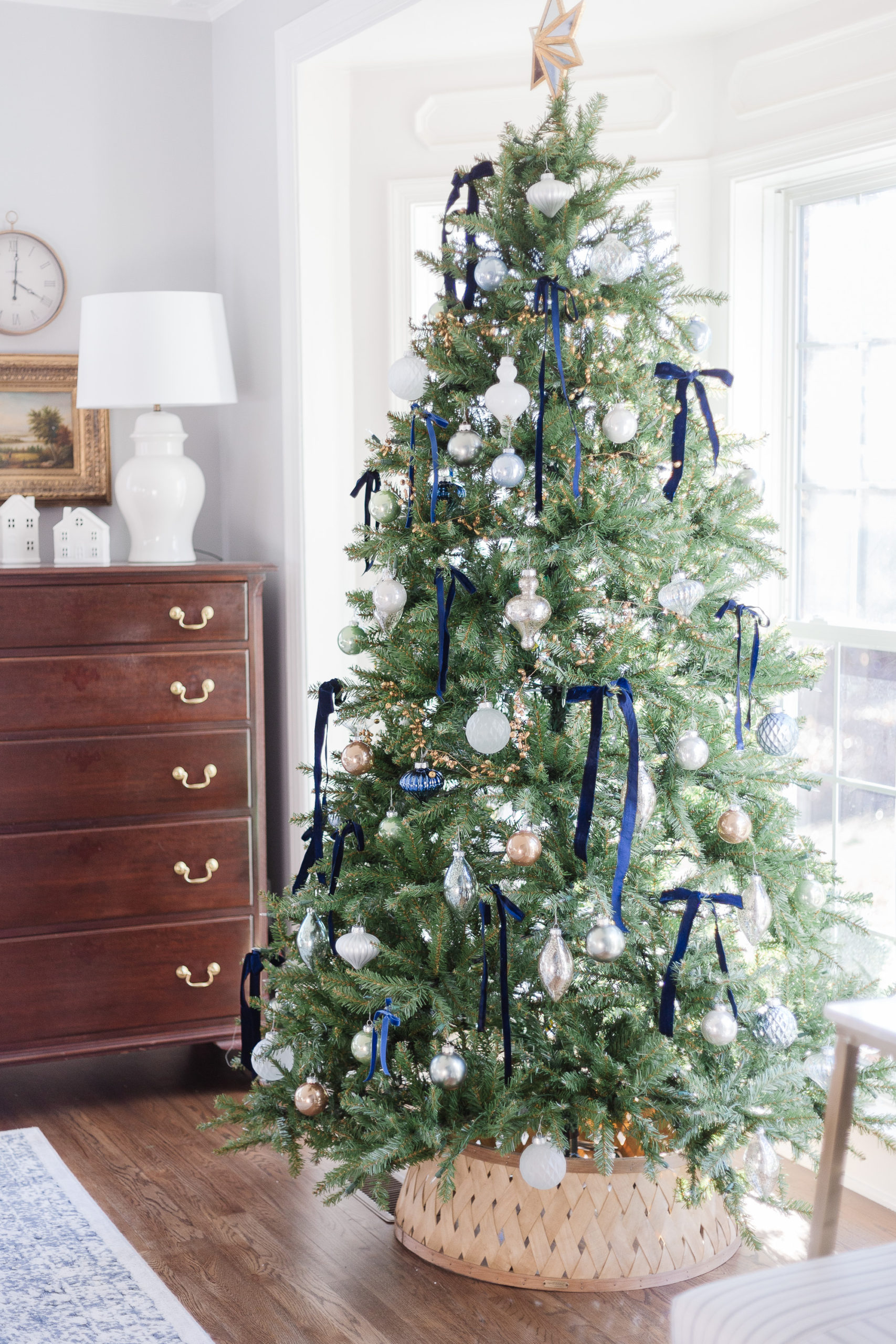 Navy blue ribbon bows and white and silver ornaments on this stunning tree / kellyelko.com