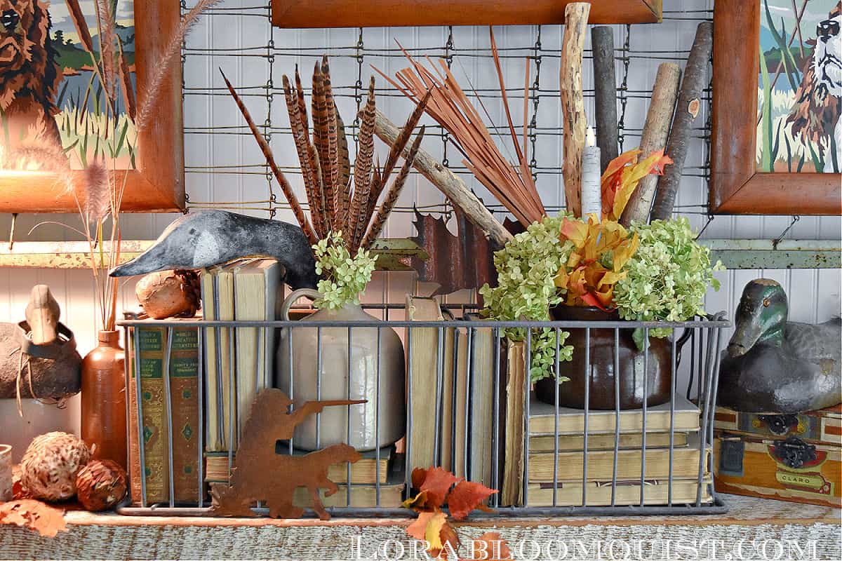 Beautiful fall arrangement of books, duck decoys, feathers and logs in a metal crate / kellyelko.com