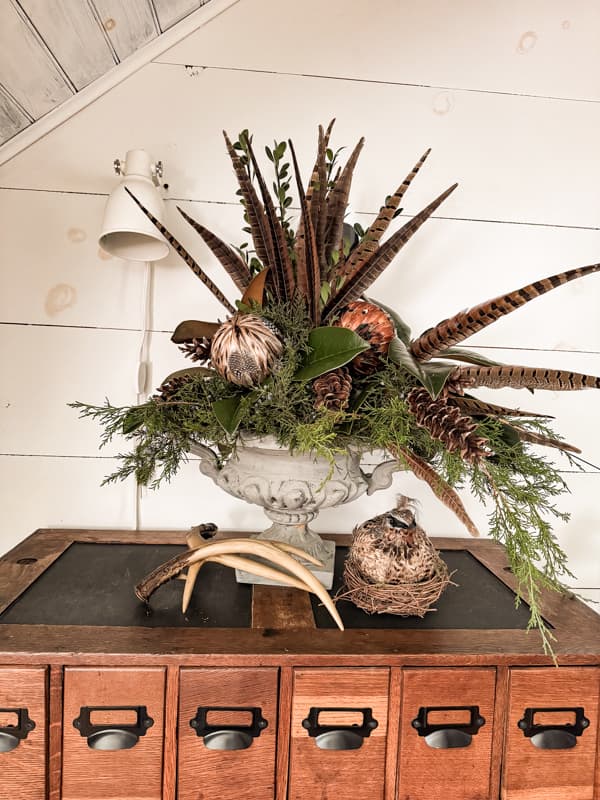 Decorating with feathers for fall in a giant urn with greens / kellyelko.com